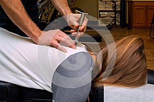 Chiropractor Uses an Integrator on the Back of a Young Girl photo