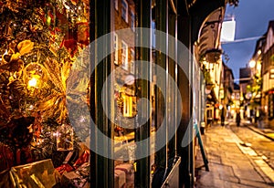 A Chirstmas night view of Shambles, a historic street in York featuring preserved medieval timber-framed buildings with jettied