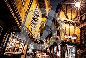 A Chirstmas night view of Shambles, a historic street in York featuring preserved medieval timber-framed buildings with jettied photo