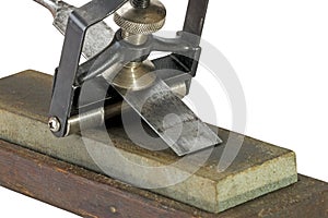 Chisel Clamped in Angle Guide Jigs on Grinding Whetstones