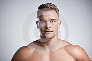 Chiselled like a prince. Studio portrait of a muscular young man posing against a grey background.