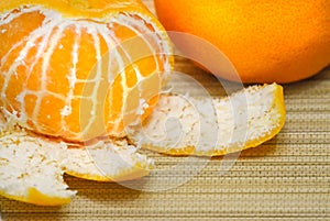 Chiselled tangerine close-up on bamboo mat photo