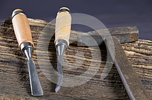 Chisels and hammer on a wooden background. Assortment of chisels of wood for carpentry. Set of chisels. A set of tools for wood