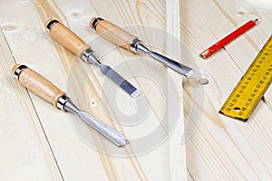 Chisels on a wooden background. Assortment of chisels of wood for carpentry. A set of tools for wood processing