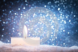 Chistmas candle glowing on glitter background photo