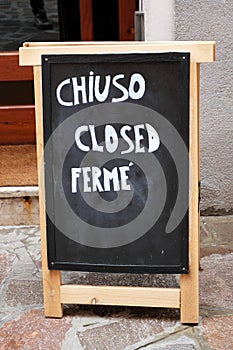 `chiuso`, `closed`, `ferme` sign written in three languages: Englih, Italian and French photo