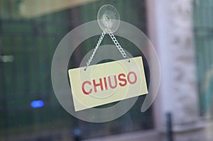 Chiuso transl. closed sign in shop window