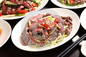 Chive fried beef with chili and onion on white plate in restaurant