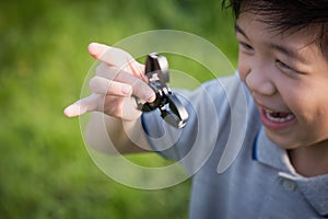 Chld playing fidget spinner on nature background