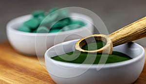 Chlorella, spirulina green algae in powder and tablets form- closeup, macro shot