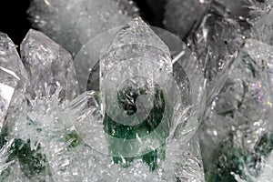 Chlorinated Quartz Crystals, black background. Large crystals green and white; surrounded by clusters of smaller crystals.