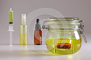 YELLOW MMS IN A HERMETIC GLASS BOTTLE WITH A DROPPER, A SYRINGE AND A SPRAY photo