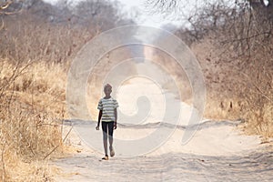 CHOBE, BOTSWANA - OCTOBER 5 2013: Poor African child wander through the desert like Chobe National Park. This year was declared