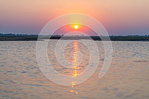Chobe River in backlight at sunset. Scenic colorful sunlight at the horizon. Wildlife Safari and boat cruise in the Chobe National