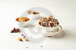 Chocolate, almonds and oatmeal energy balls in white bowl on white background