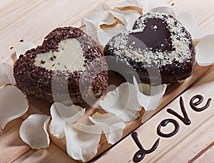 Chocolate baked in the shape of heart and beautiful light rose flower.