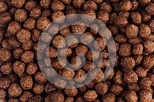 Chocolate balls corn flakes closeup background. Cereals texture.