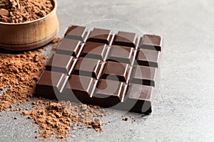 Chocolate bar and cocoa powder on grey