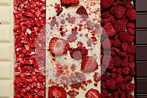 Chocolate bar with different freeze dried fruits as background, top view