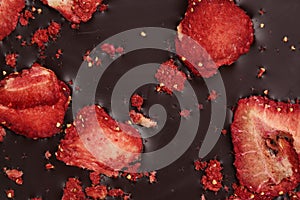 Chocolate bar with freeze dried strawberries as background, closeup