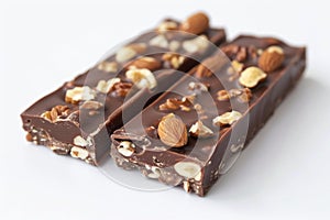 Chocolate bars with almonds and nuts lying on white surface