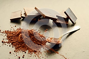 Chocolate bars with heap of cacao powder
