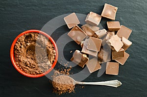 Chocolate bars with heap of cacao powder