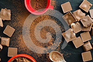 Chocolate bars with heap of cacao powder