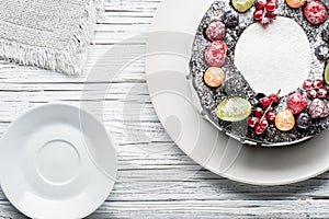 chocolate berry cake on plate over white wooden background