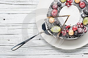 Chocolate berry cake on plate over white wooden background