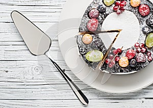 Chocolate berry cake on plate over white wooden background