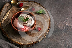 Chocolate berry ice cream in the bowl on the stump board, selective focus, dark background. Copy space