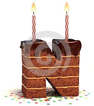 Chocolate birthday cake with lit candle and confetti 3d font letter N