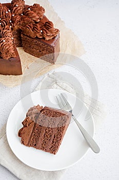Chocolate Birthday cake. A slice of delicious chocolate cake on a light background. Piece of Cake on a white Plate. Sweet food.