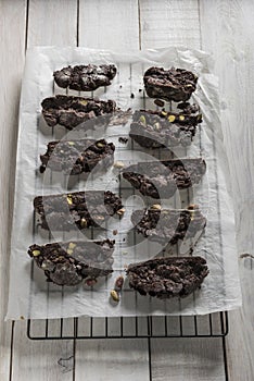 Chocolate biscotti or cantuccini with pistachios on baking paper.