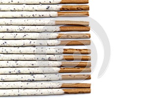 Chocolate biscuit stick coated with milk flavour confectionery and crushed cookies and cream taste  on white background