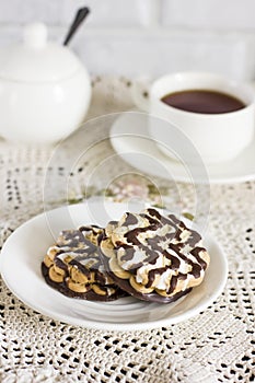 Chocolate biscuits on white plate and Cup of tea on table
