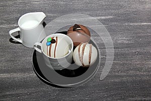 Chocolate bombs in mug with hot milk, filled with marshmallows and white chocolate on vintage gray background