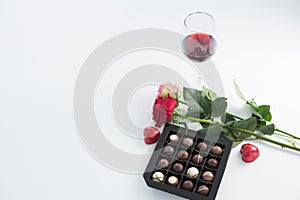Čokoláda krabice růže a červené víno sklo na bílém 