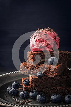 Chocolate brownie with blueberry and ice cream on the vintage plate vertical
