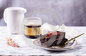Chocolate brownie cake with berries red currant and cup of coffee