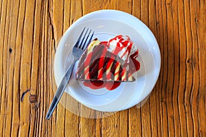 Chocolate brownie cake with strawberry sauce and cream