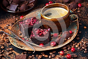 Chocolate brownie cakes dessert with cranberry and  coffee mug on  dark background