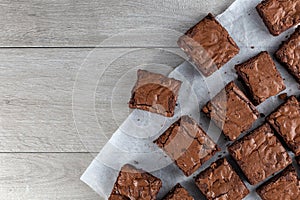 Chocolate brownie on paper on dark grey base top view flat lay photo