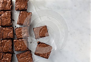 Chocolate brownie on paper on marble top view flat lay photo