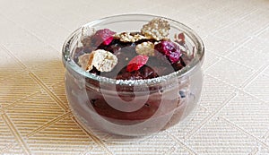 Chocolate budino with dryed raspberries and corn flakes in a glass jar