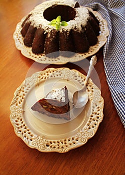 Chocolate bunt cake sprinkled with fruit ,sugar powder on a plate white background