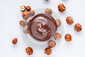 Chocolate butter and hazelnuts on a white acrylic background