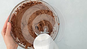 Chocolate buttercream frosting, mixing ingredients in glass bowl using an electric mixer