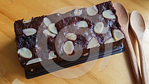 Chocolate cake with almonds on top on wood background